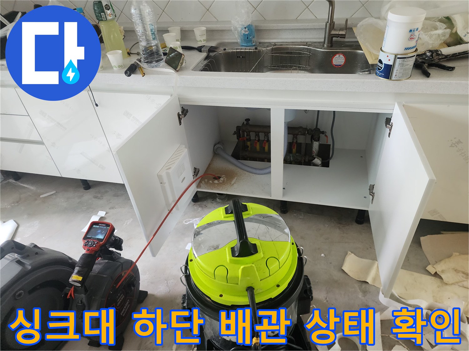 싱크대 아래쪽의 배관 노출 부위와 작업용 석션기