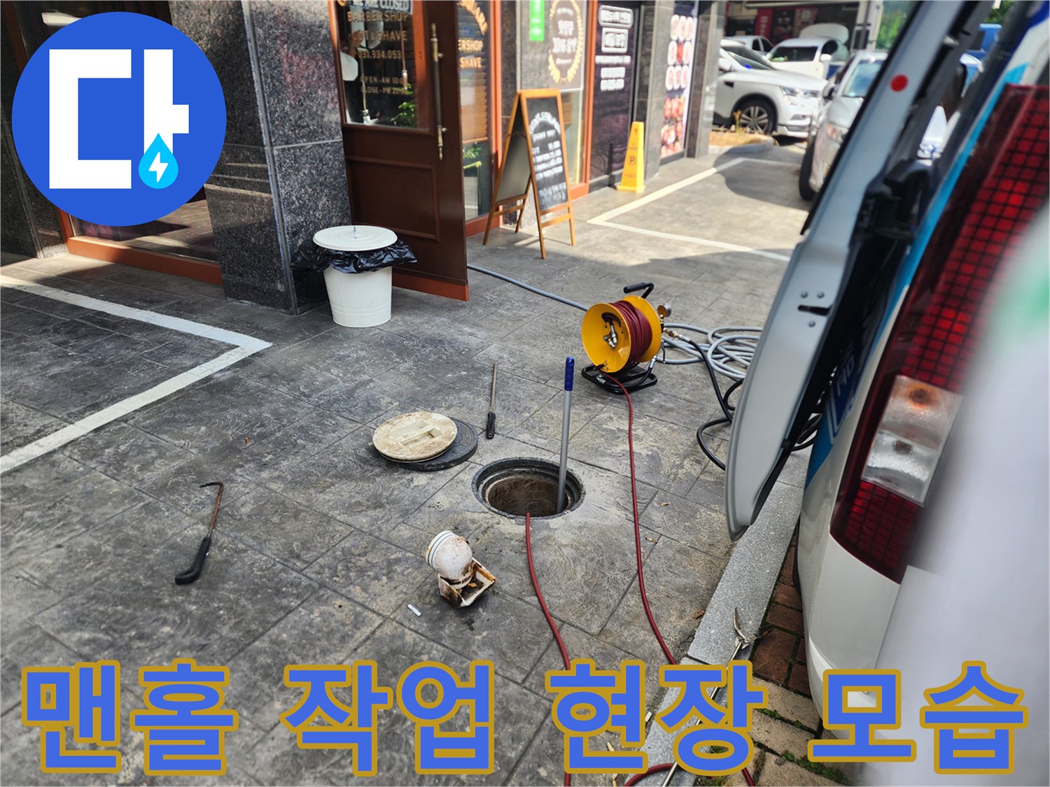 매장 앞 맨홀 주변에 배치된 고압 세척 장비와 배관 입구입니다.