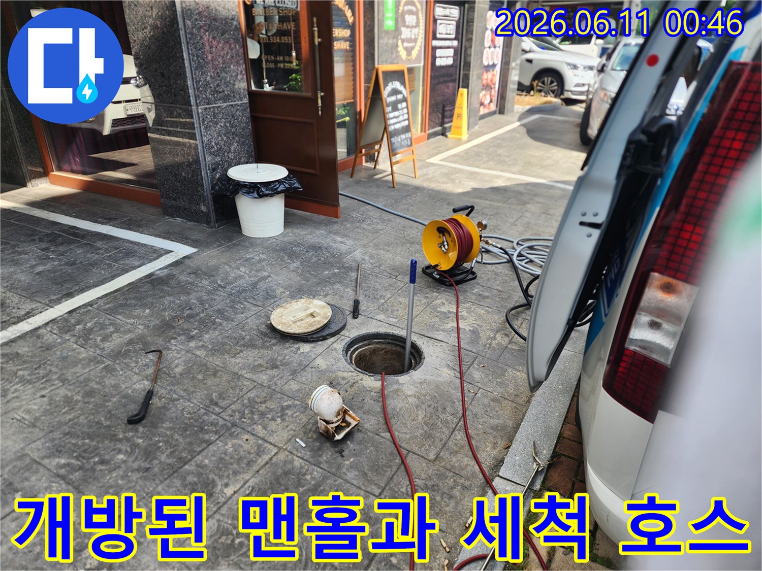 바닥 맨홀 입구에 투입된 고압 세척 노즐과 배관 작업 도구들