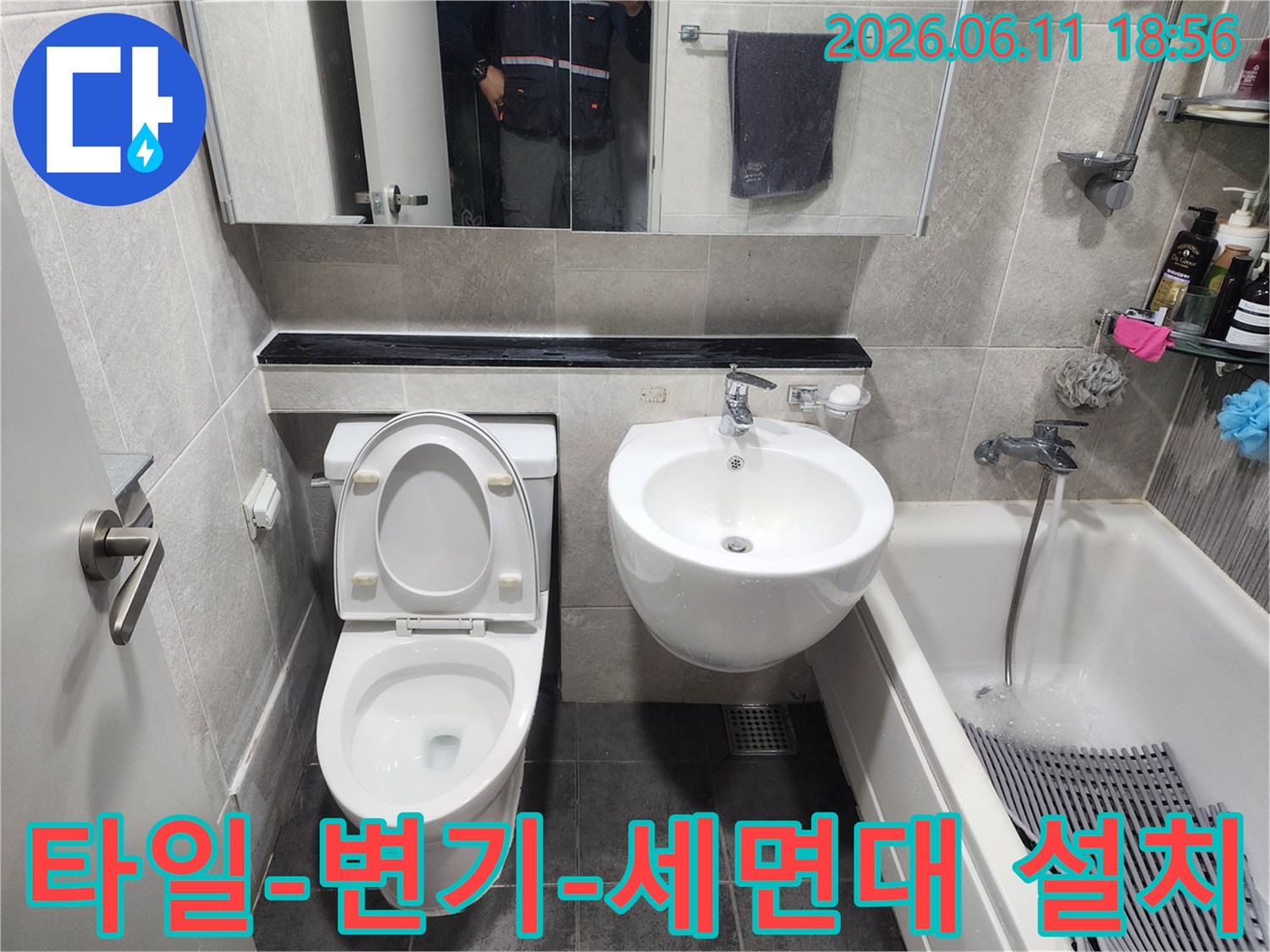 쌍용아파트 화장실의-배관 수리 작업이 끝난 후-타일 시공과 함께-변기 및 세면대가-완벽하게 부착된-욕실의 최종 마감 상태입니다.