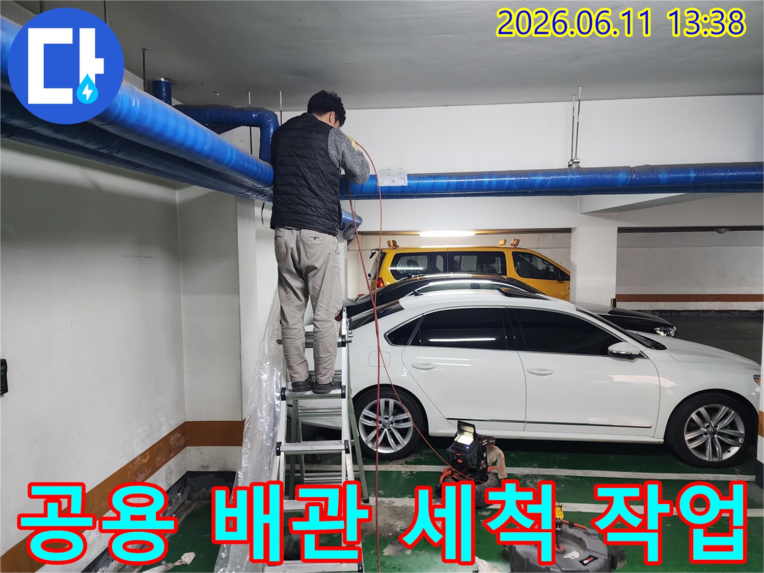 사다리 위에서 파란색 배관을 점검하는 기술자의 작업 모습