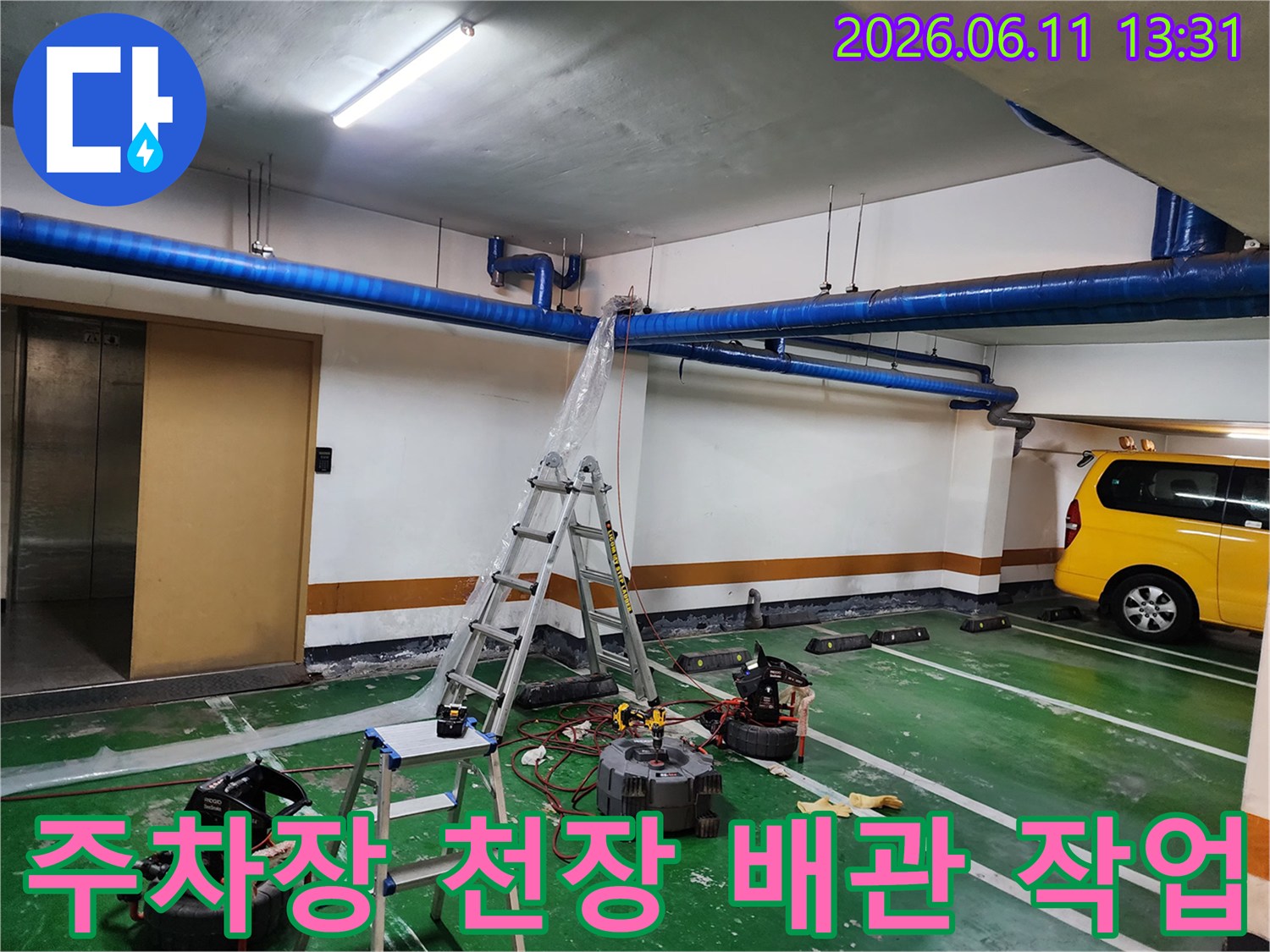 지하주차장-천장에 설치된 파란색 배관을 점검하는 모습
