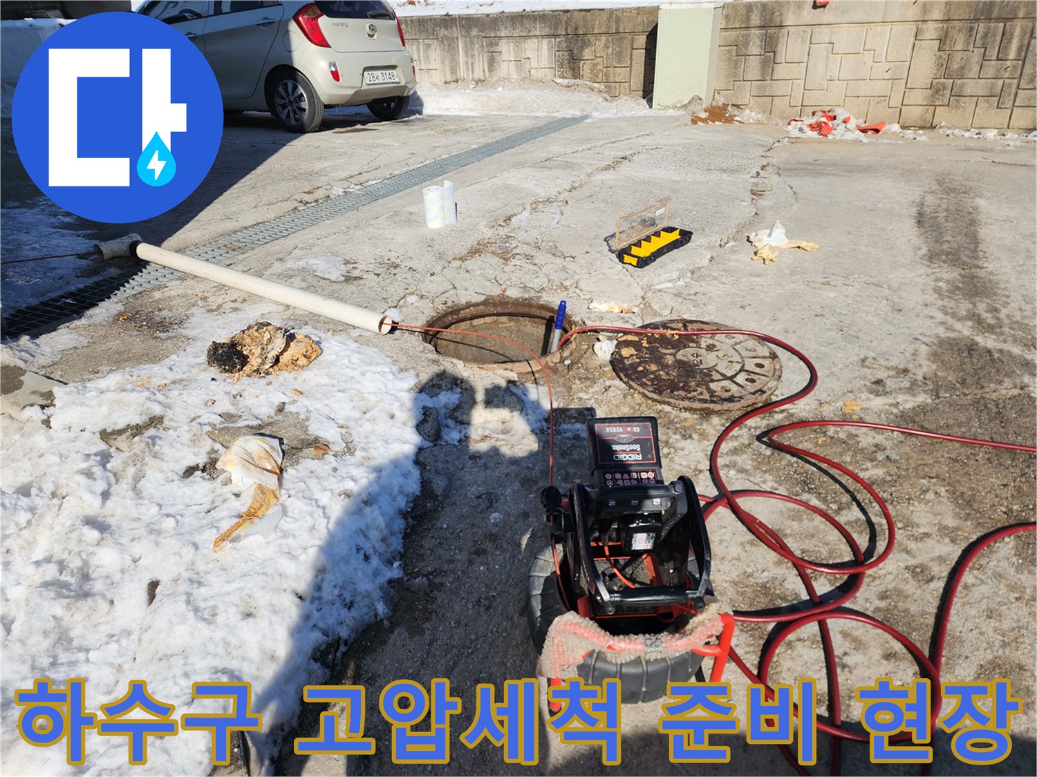 맨홀 옆에 배치된 배관 내시경 모니터와 붉은색 호스