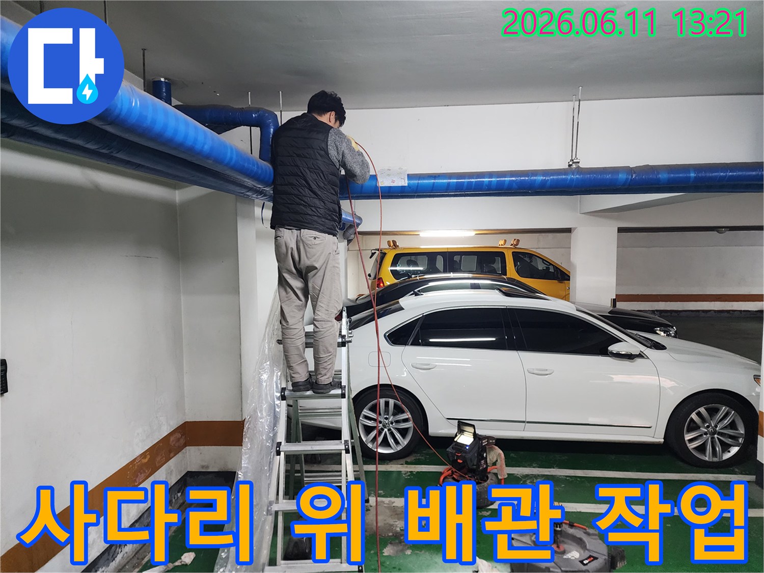 지하주차장 천장-노출된 공용 배관의 막힘 제거를 위한 사다리 작업