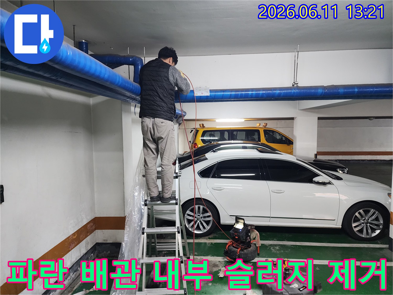 천장 파란색 배관을 대상으로 고압 세척 작업을 진행하는 모습