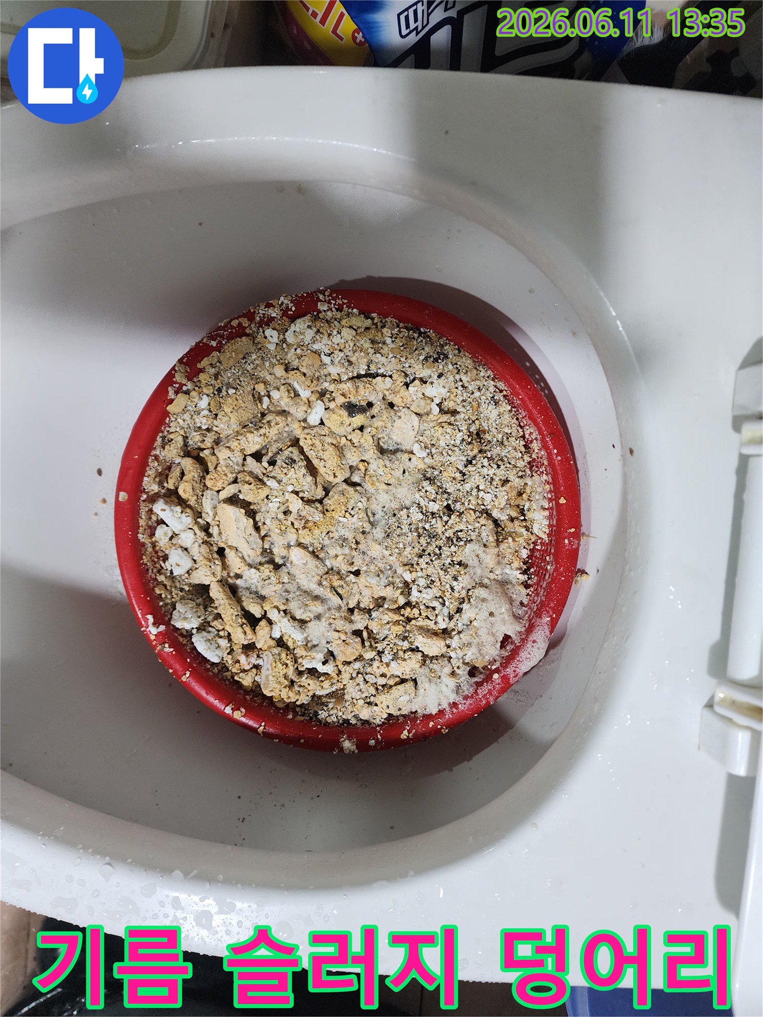 석션기를 통해 배출된 하얀색과 갈색이 섞인 기름 슬러지 덩어리들