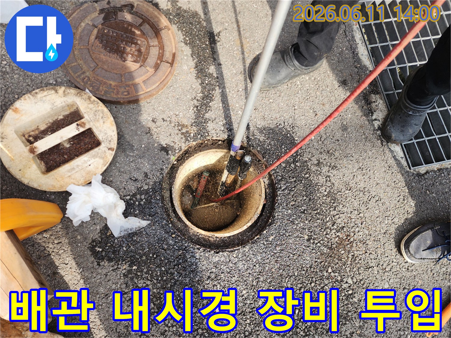 맨홀 입구에 배치된 배관 내시연 카메라와 작업자의 모습