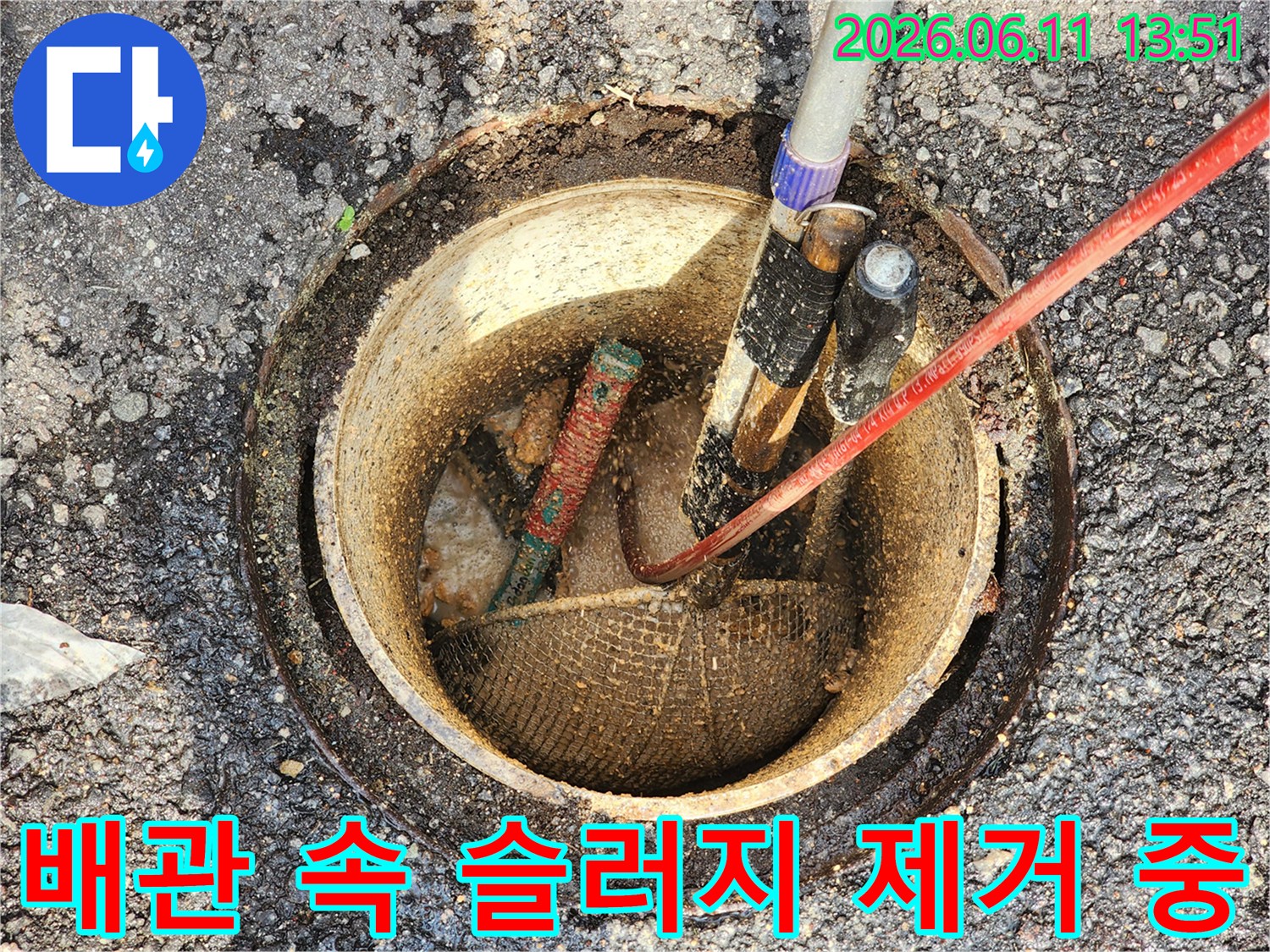슬러지로 가득 찬 맨홀 배관에 투입된 세척용 호스와 장비들