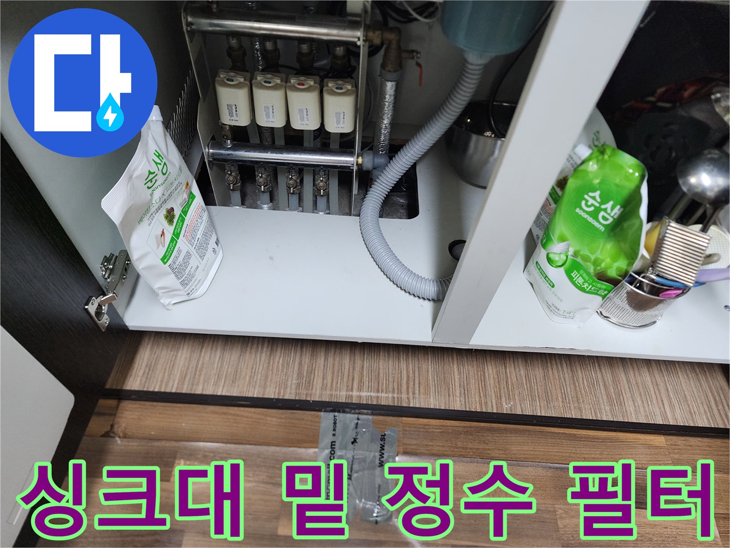 싱크대 하단에 배치된 여러 개의 정수 필터와 연결 호스들입니다.