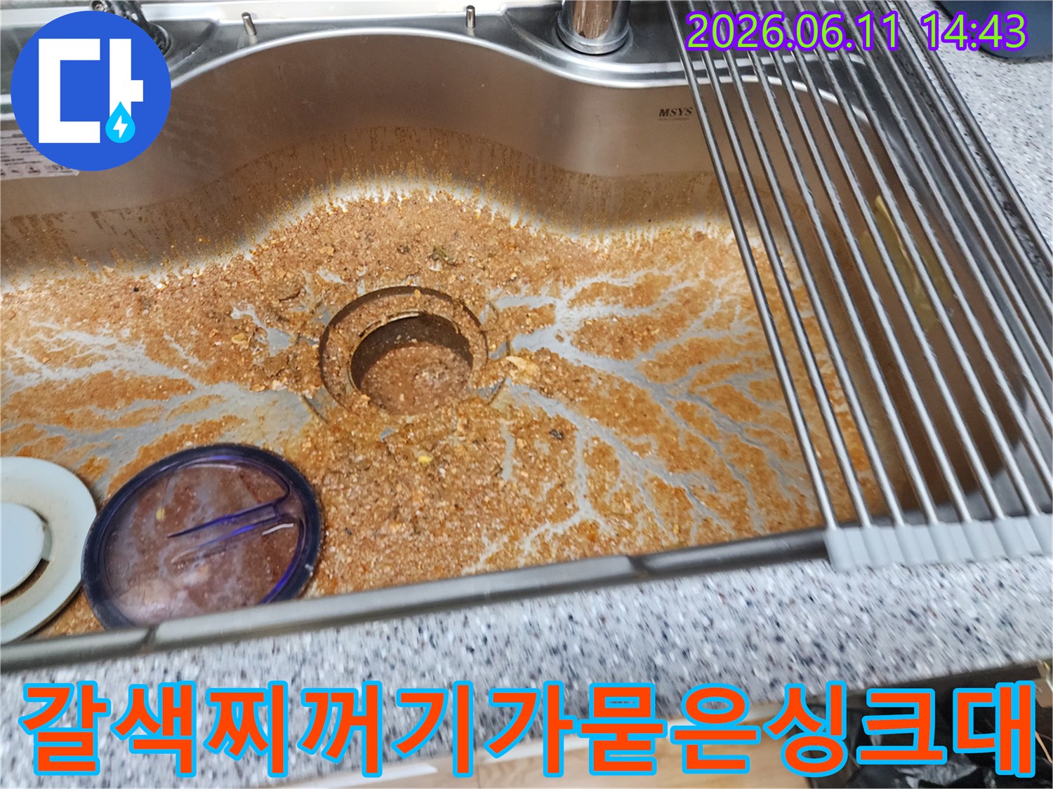 배수구 주변에 갈색 기름때가 심하게 끼어 있는 싱크대 사진입니다.