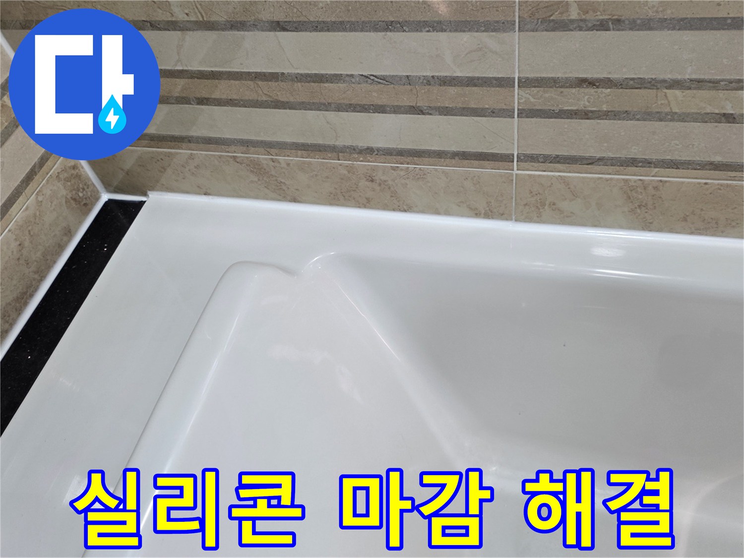 이 이미지는 욕실의 욕조와-벽 타일 경계면의-이전 실리콘 마감 불량을-새로운 방수 실리콘으로-깔끔하게 해결한 모습을 보여주며-이는 누수 문제를 근본적으로-차단하는 작업입니다.