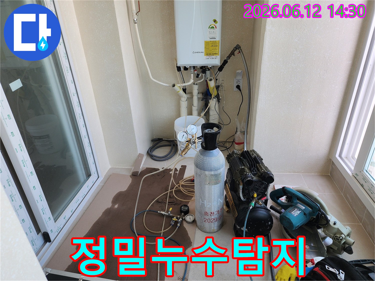누수 탐지를 위해-수소 가스 주입 장비와-콤프레셔가 설치된-베란다 작업 현장입니다