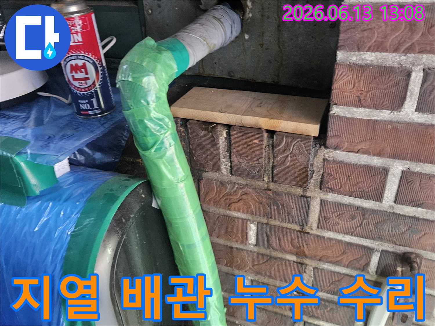 주택 벽면에서 나온 지열 보일러 배관의 누수 지점을-특수 테이프로 감싸고 토치로 열처리하여 수리하는 모습