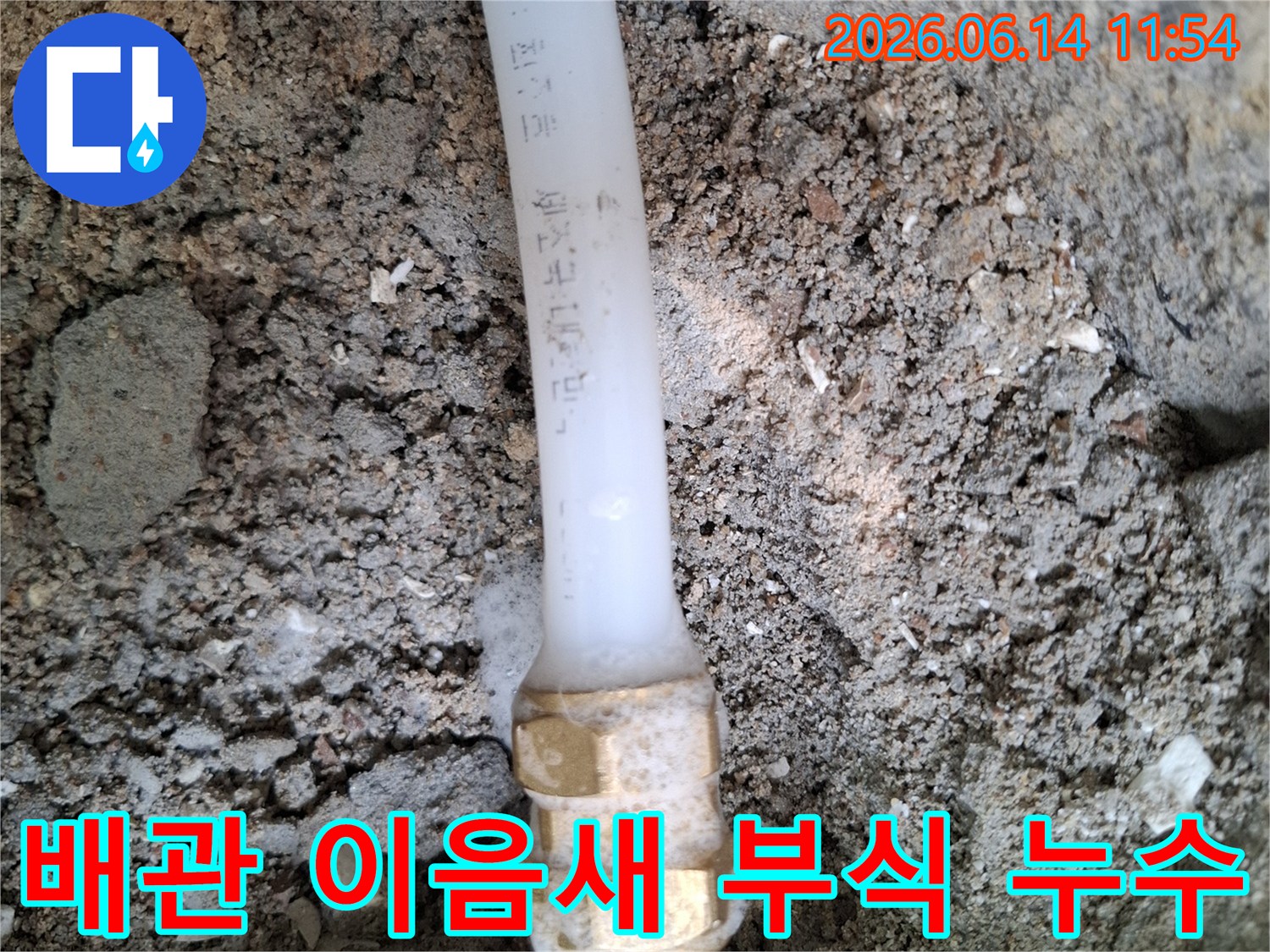 땅속에-묻힌-배관의-금속-연결부에서-부식으로-인한-누수가-발생하여-주변-흙이-젖어있는-모습을-보여주는-사진