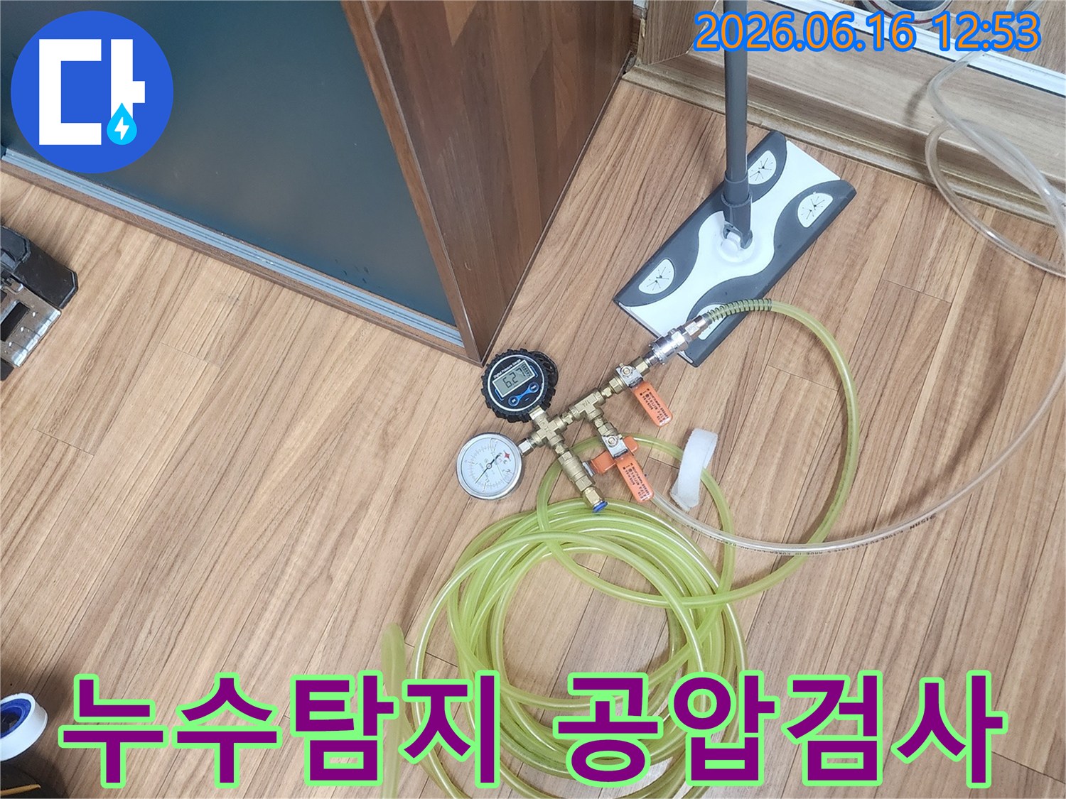 누수 탐지 엔지니어가 직수 배관의 압력 손실을 정밀하게 측정하기 위해 공압 검사 장비를 연결하는 현장 작업