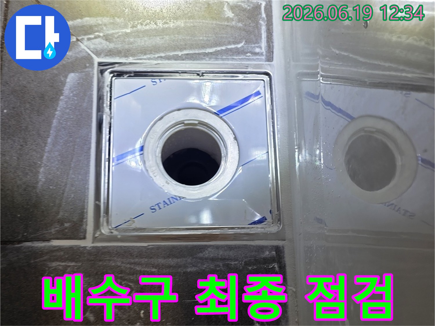 보호 필름이 덮인 배수구가-완벽하게 설치된 모습을 보여주며-모든 시공 과정이 마무리된 후 최종 점검 중임을 암시하는 이미지