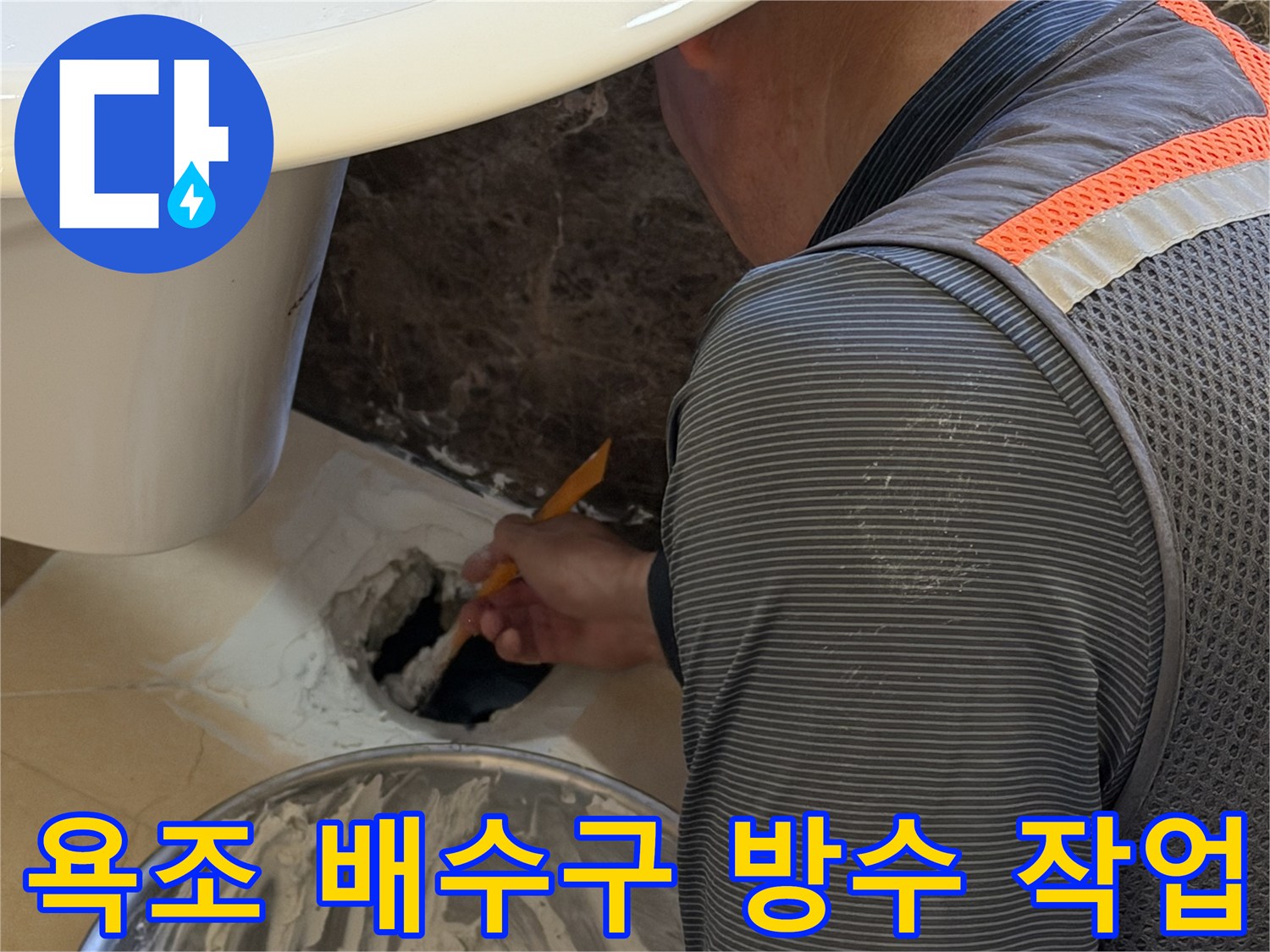 욕조 배수관 주변에 방수액을 꼼꼼하게 채워 넣는 시공 장면