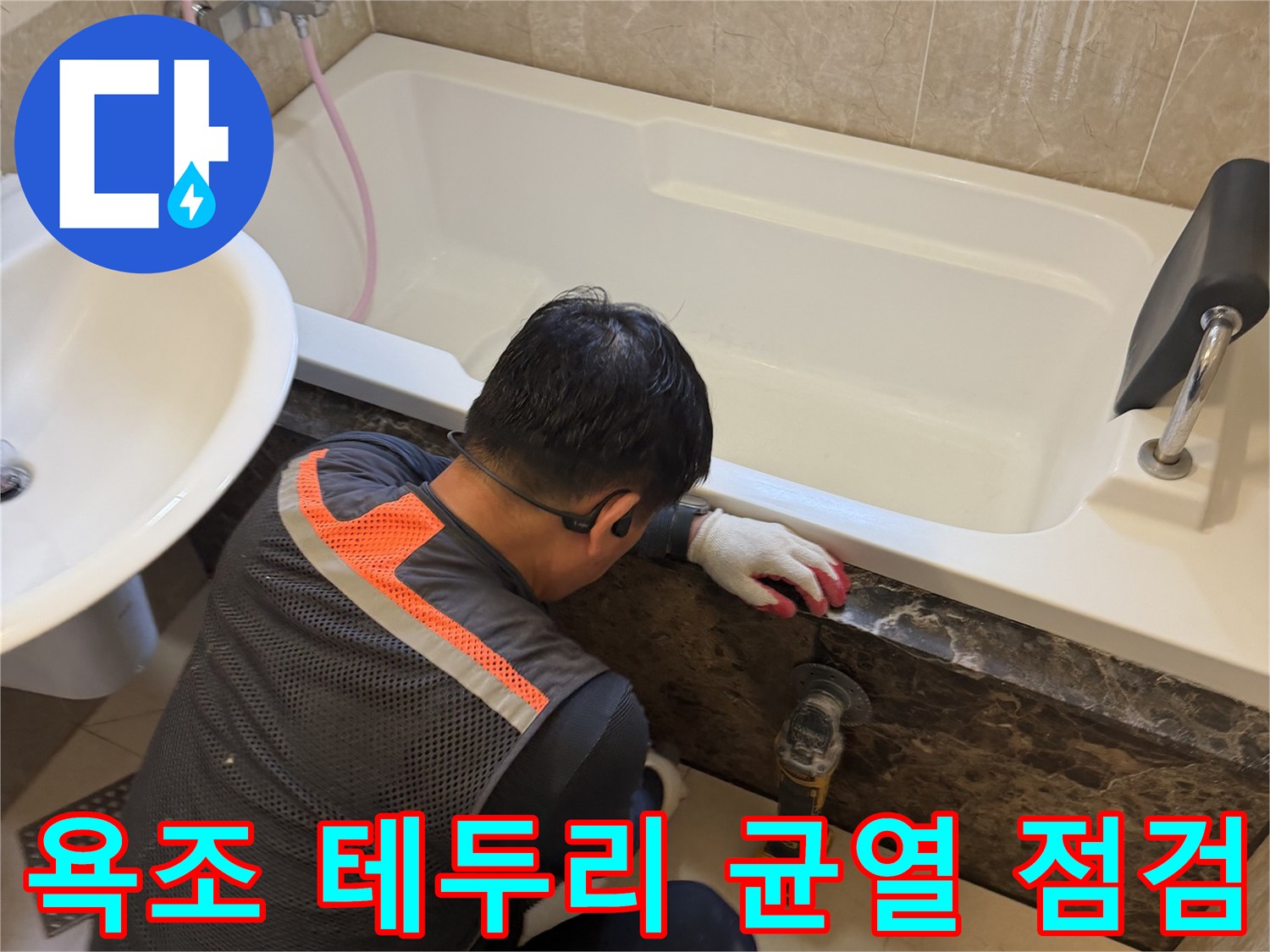 현장 작업 - 욕조와 어두운 석재 마감 부위의 접합 상태를 면밀히 관찰함