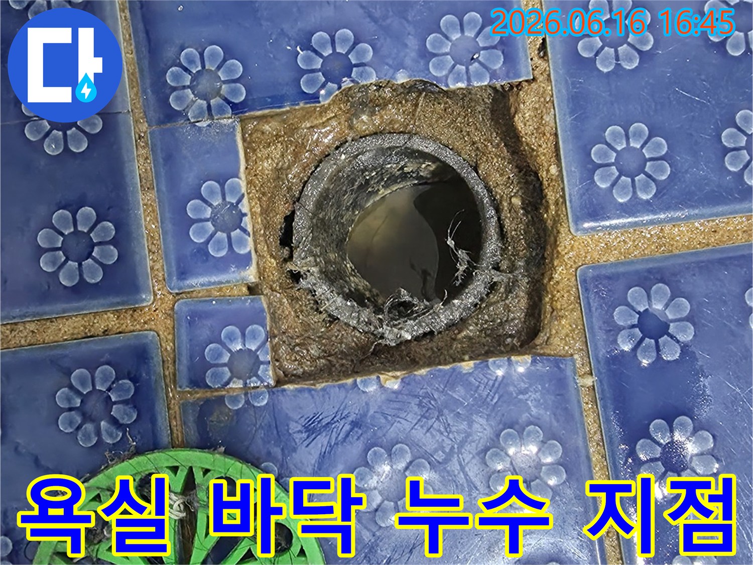 배수구-안에-고인-물과-주변-타일의-파손이-보이는-욕실-누수-문제-이미지