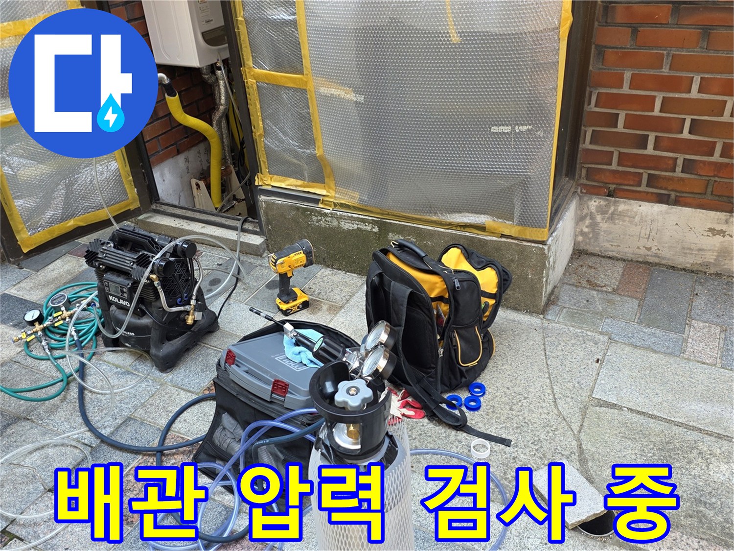 수도 배관의 기밀 상태를 체크하기 위해 콤프레샤와 압력계가 연결된 모습