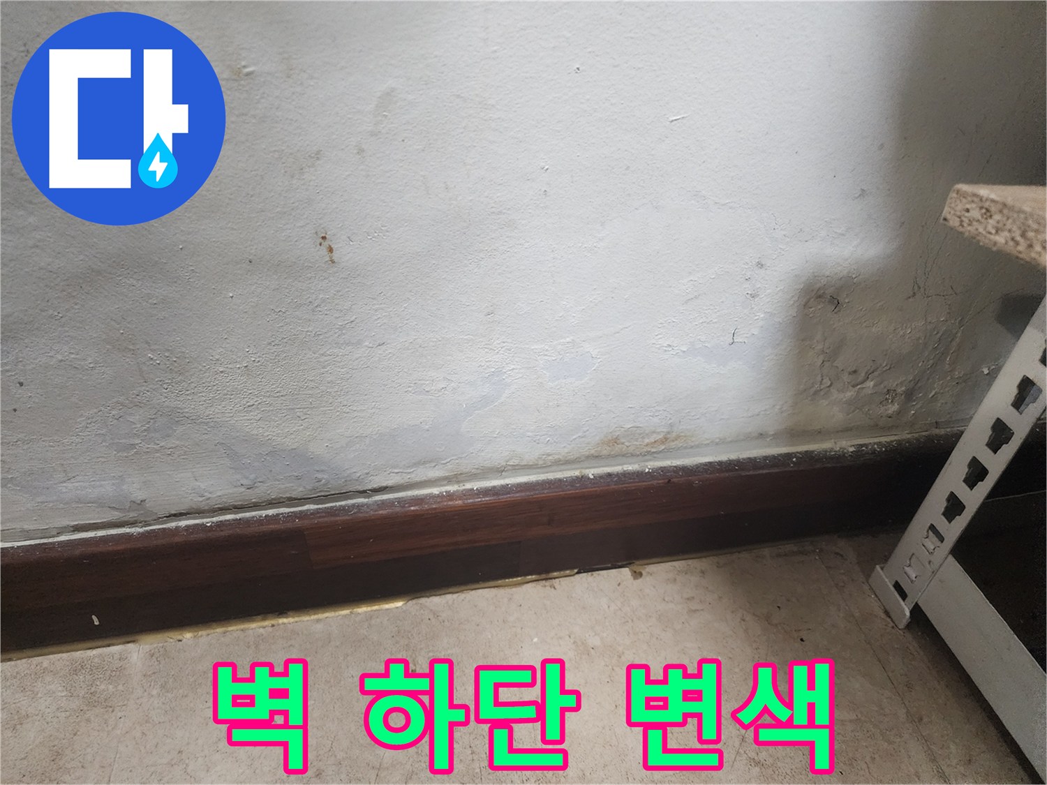 벽 하단부에 물이 스며들어 벽지가 젖고 곰팡이가 피어있는 누수 피해 현장 사진입니다.