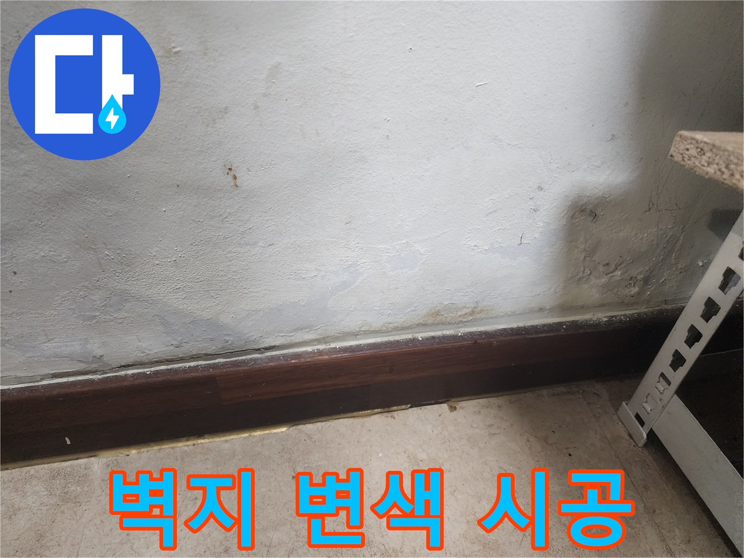 벽 하단부에 물이 스며들어 벽지가 젖고 곰팡이가 피어있는 누수 피해 현장 사진입니다.
