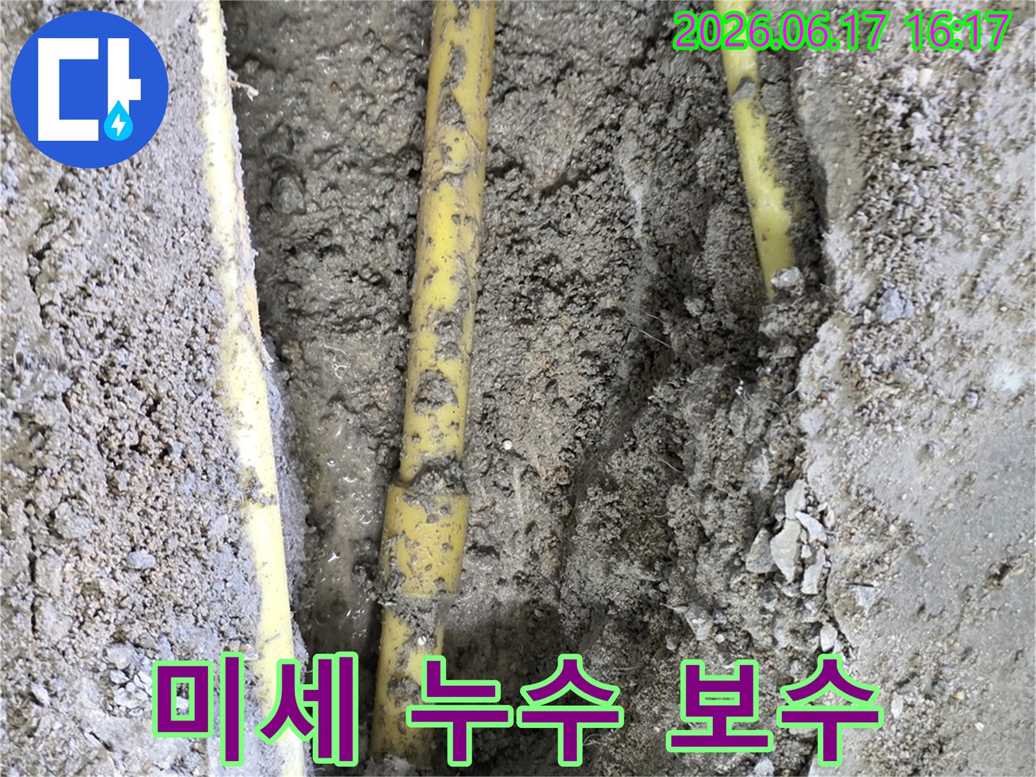 땅속에 묻힌 노란색 배관에서 육안으로 확인하기 어려운 미세 누수 지점이 탐지 후 보수를 위해 드러난 모습입니다.