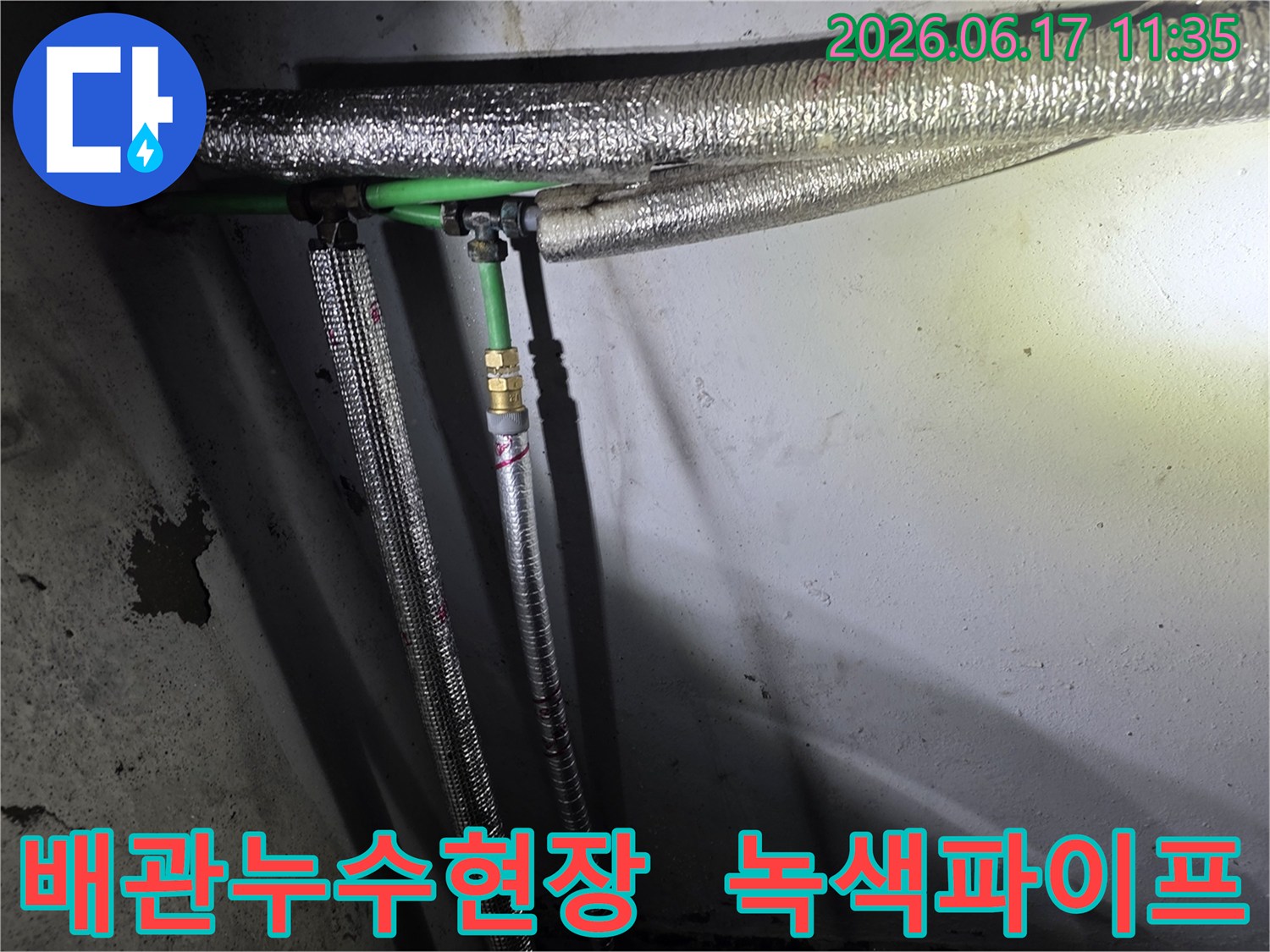 누수 공사 현장에서-발견된-녹색 배관과-은색 보온재로 감싸인-수도관 연결부의 모습