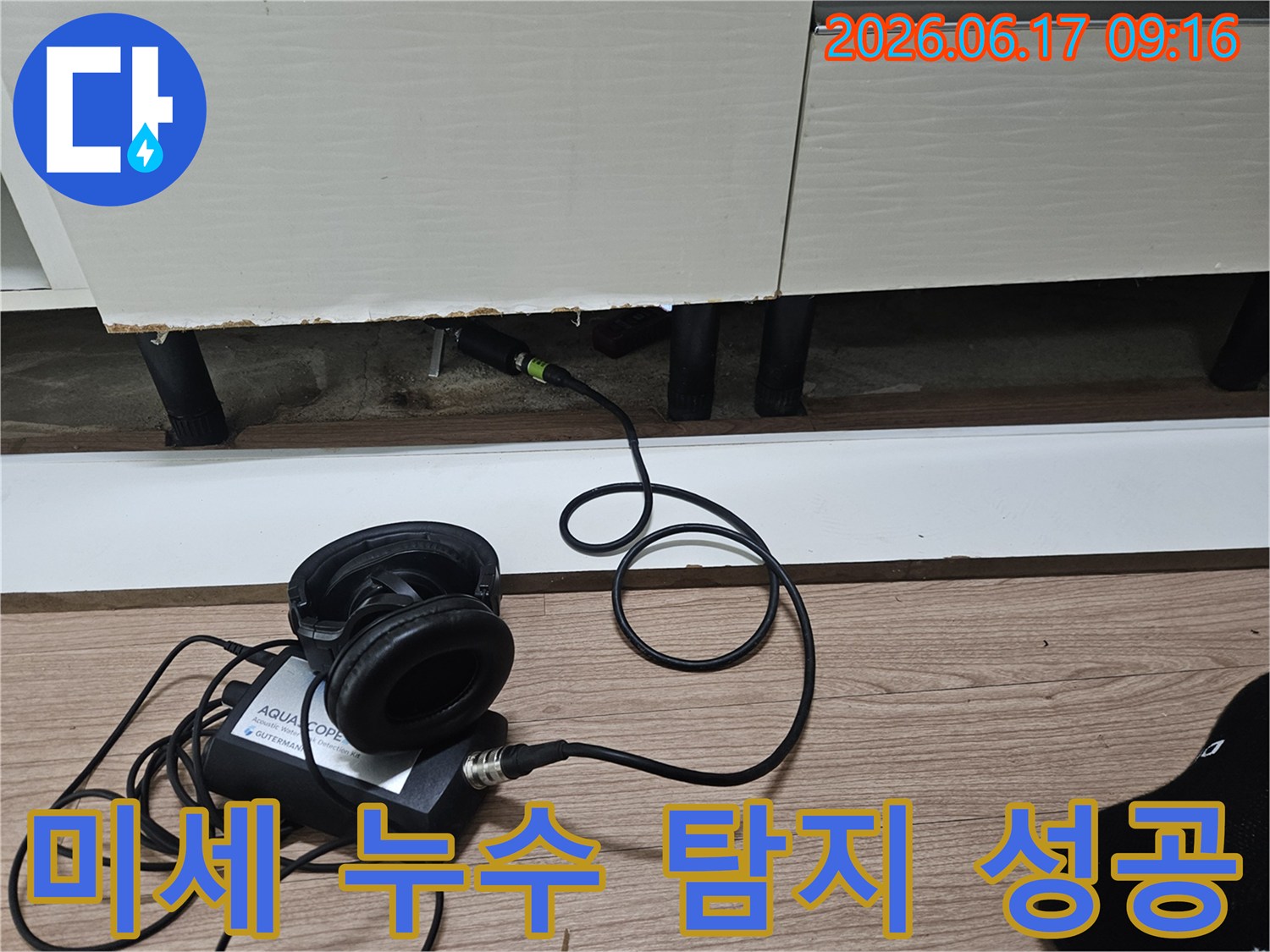누수 탐지 엔지니어가-청음식 장비를 사용하여-싱크대 하부의 미세한 누수음을 성공적으로 탐지하는 모습