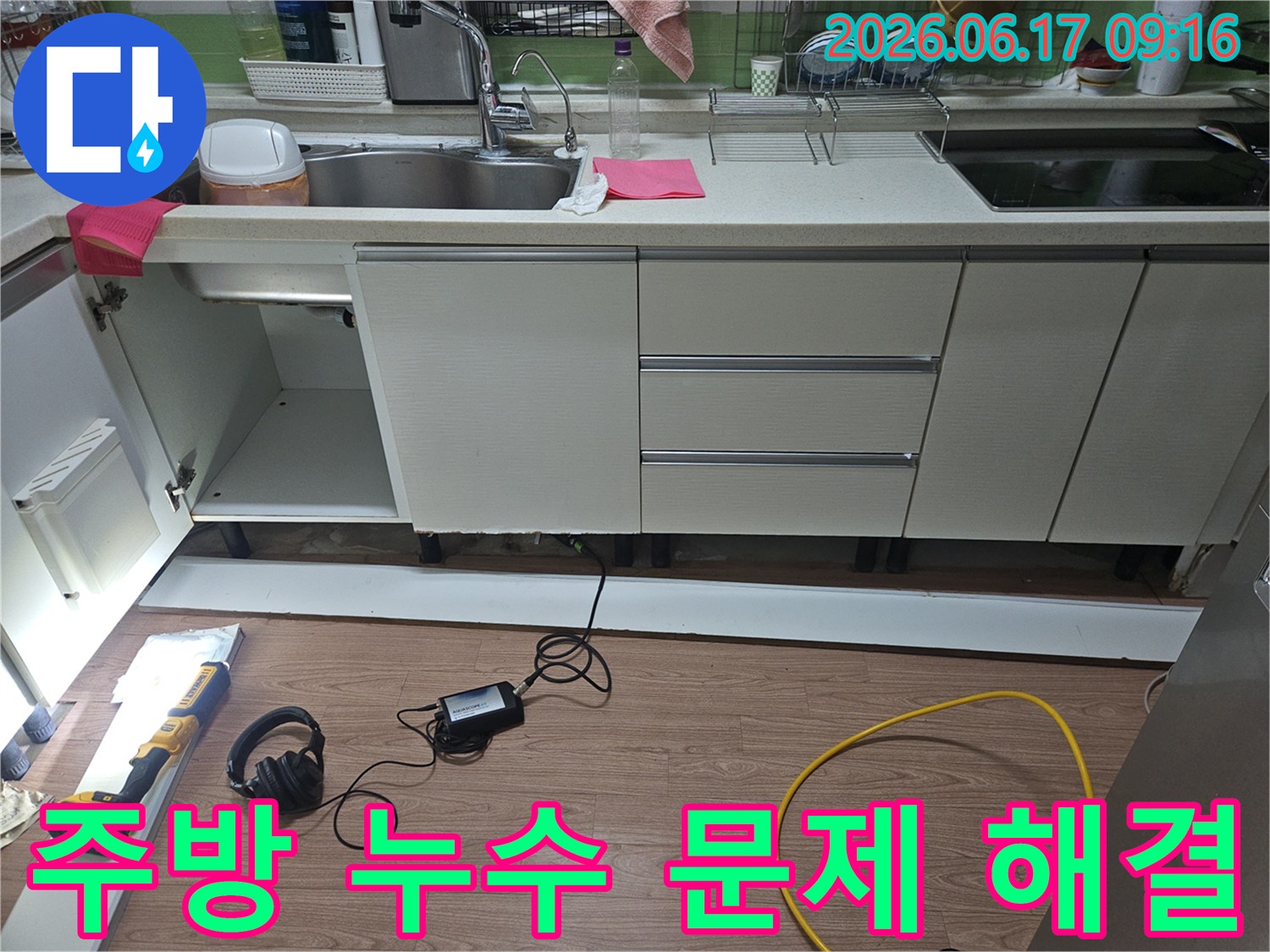 초월읍 싱크대 주변에서-발생한 누수의 정확한 위치를 파악하기 위해-전문 장비를 사용하여-주변 공간을 정밀하게 탐지하는 모습