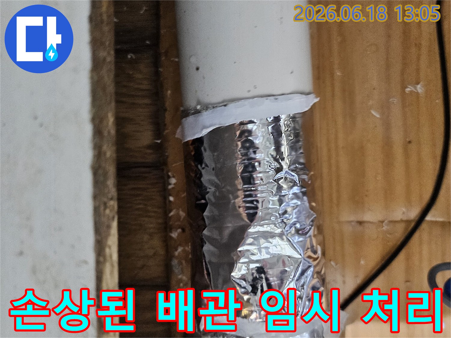 손상된 배관 부위를 알루미늄 호일과 테이프로 임시 보수한 모습-누수 공사 전 단계