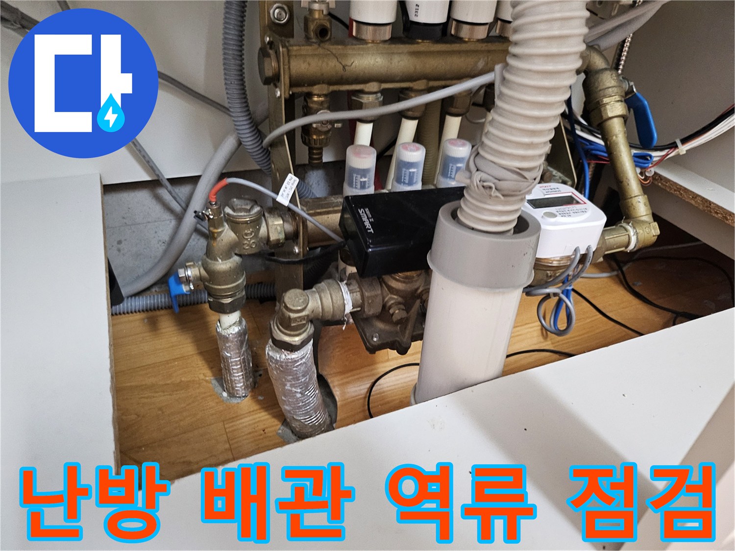 이 이미지는 물이 역류하는 문제로-점검 중인 아파트 보일러 배관과-분배기 시스템을 보여줍니다