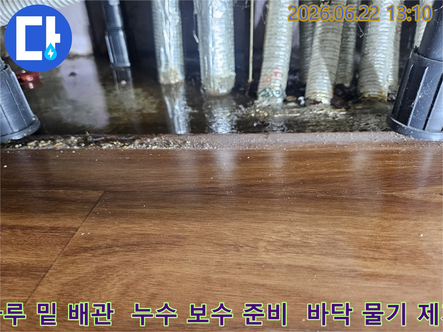 마루 밑-배관에서-물이-새어-나와-고여있는-모습을-보여주며-보수-작업-전-사진
