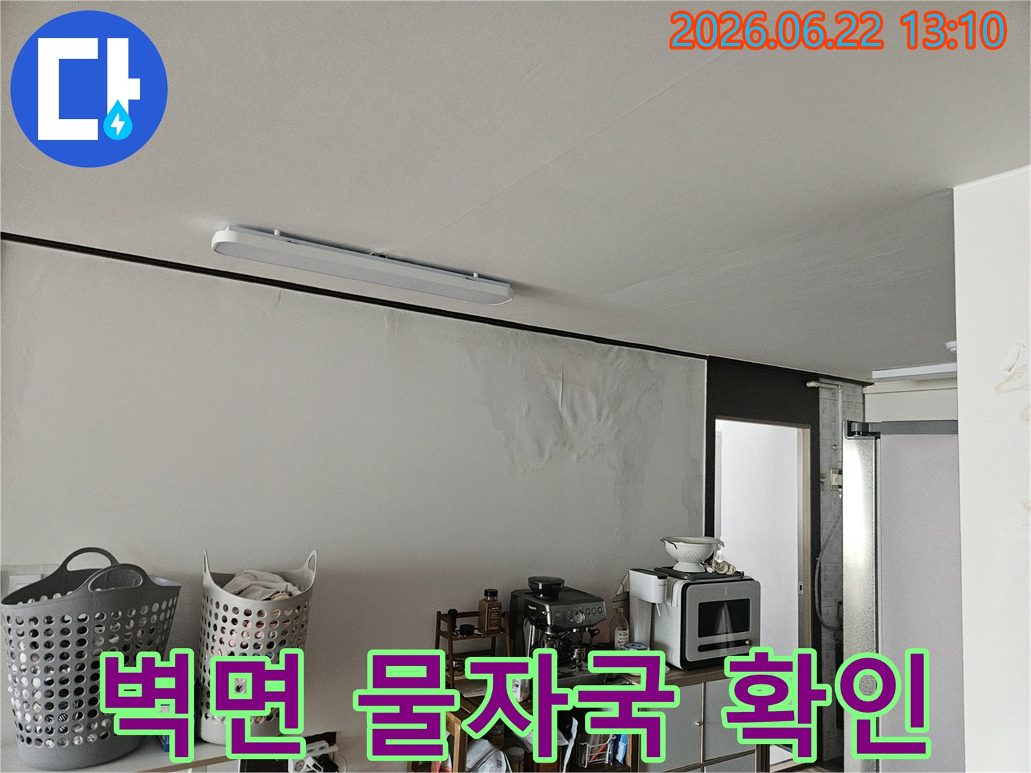 아파트 천장에서 물이 새어 벽면으로 흘러내려-벽지가 축축하게 젖고 들뜬 심각한 누수 피해 현장을 담고 있습니다.