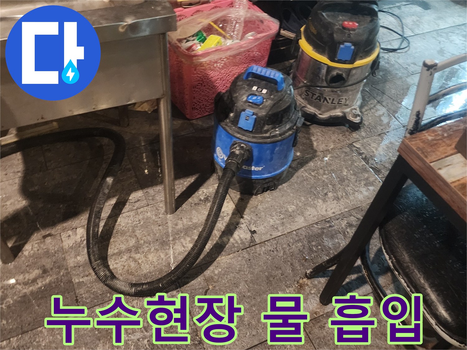 누수 발생 현장에서-바닥에 고인 물을-효율적으로 제거하기 위해-사용되는-두 대의 산업용 습식 청소기가-작동 준비를 마친 모습입니다.