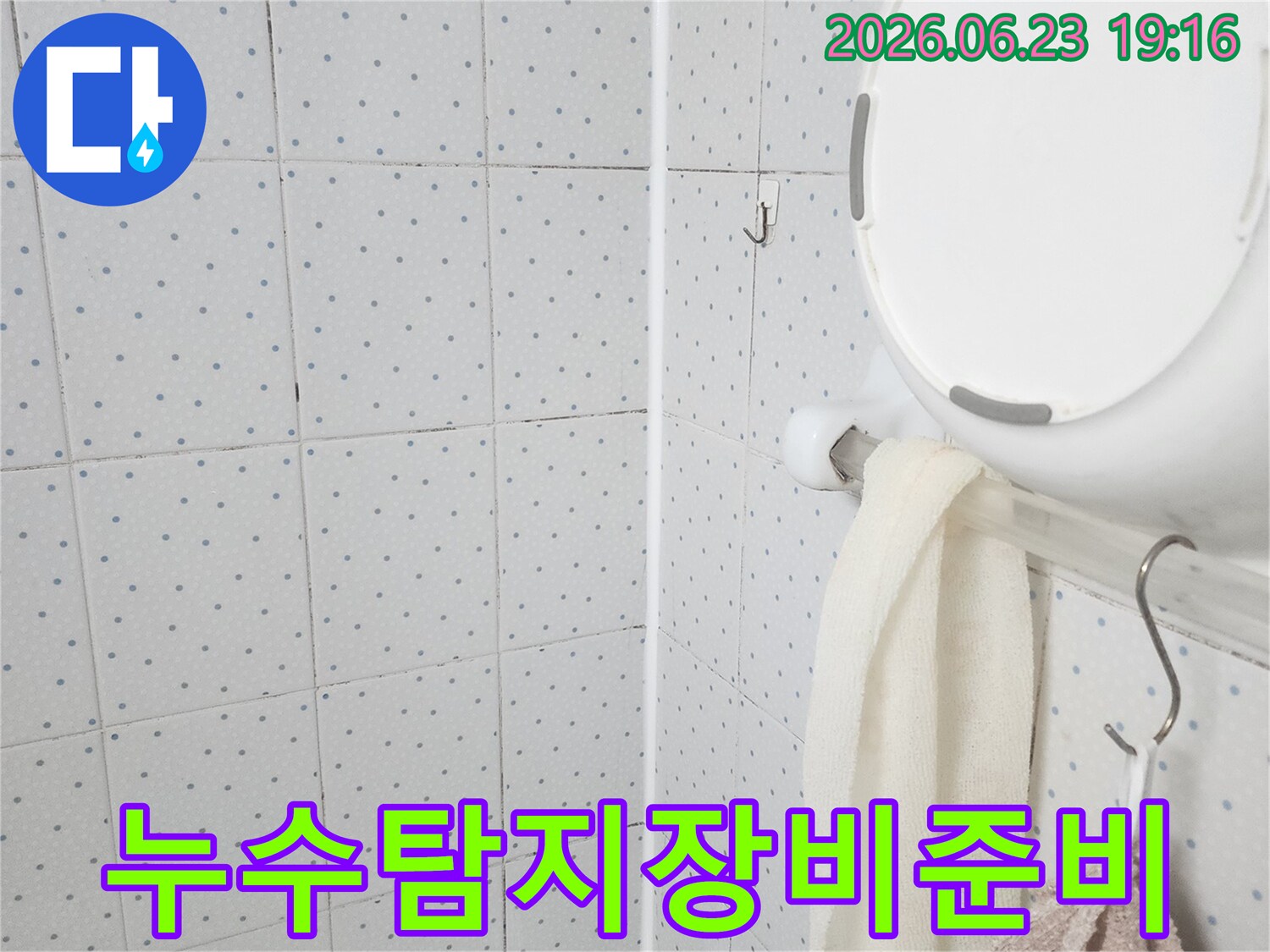 이 이미지는-욕실 천장의-누수 현장을-정밀하게 탐지하기 위해-전문 장비를-준비하는-초기 단계를-보여주고 있습니다.