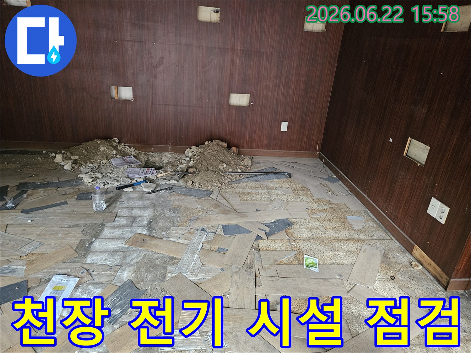 이 이미지는 천장 누수로 인해 마감재가 손상되고-전기 시설에 문제가 발생할 수 있는 현장을 점검하는 모습을 보여줍니다