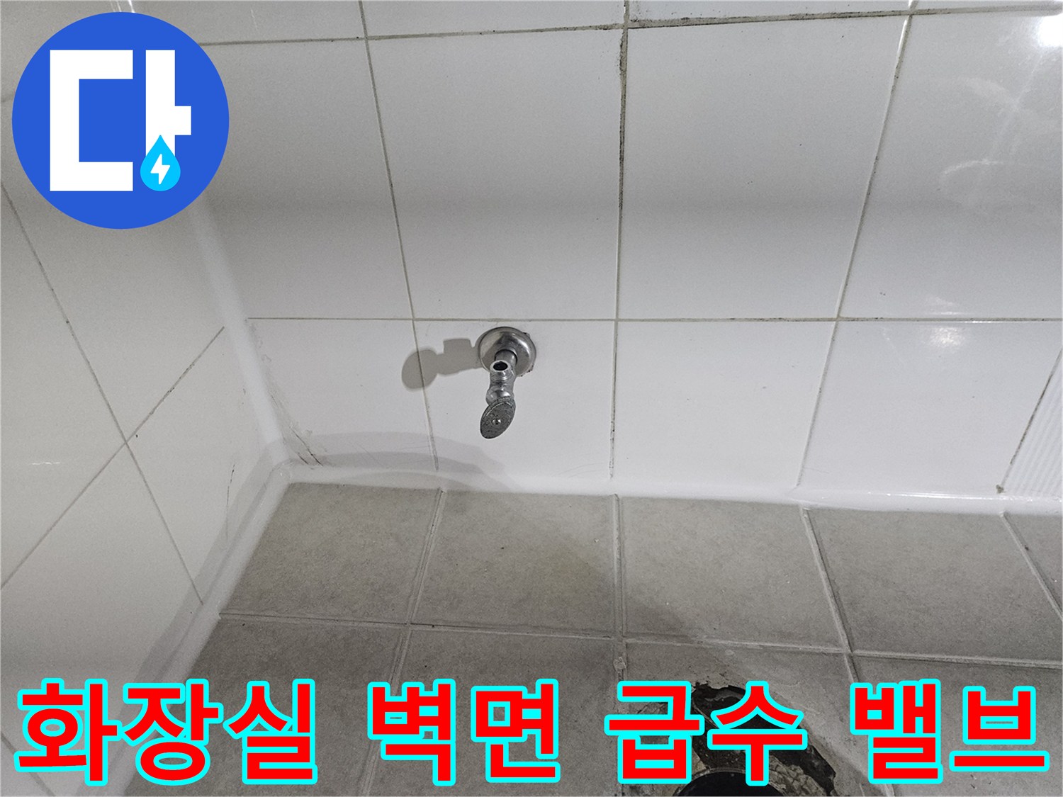 화장실 벽면에 설치된 금속 재질의 급수 밸브 모습입니다.