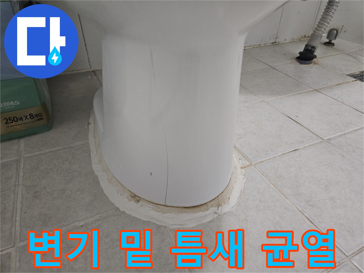 화장실 변기 하단부의 갈라진 마감재와 오염된 타일 주변 모습