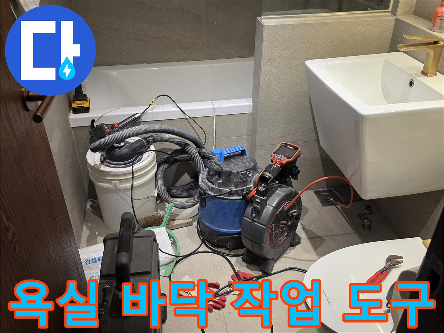 세면대 아래 배치된 배관 청소기 및 공구들