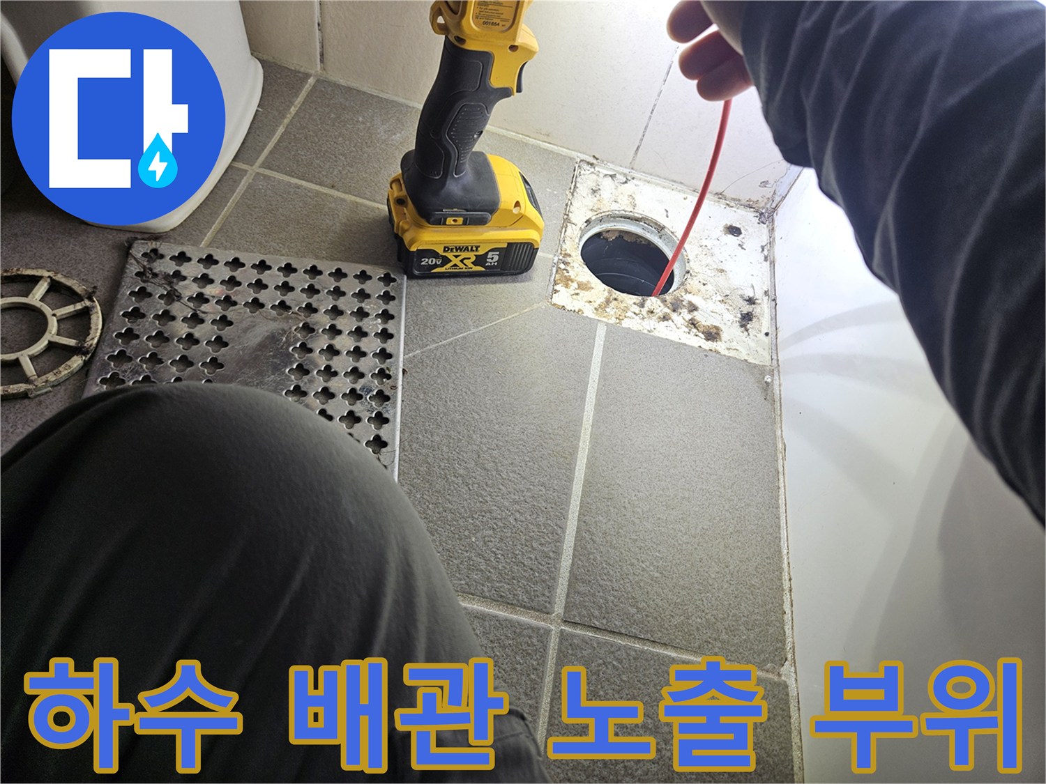 노출된 하수 배관과 작업 중인 전동 드릴의 모습