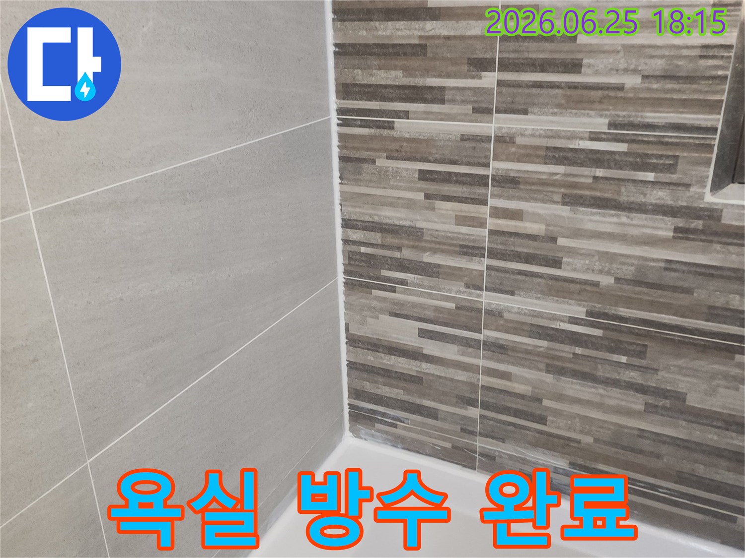 누수 공사 완료 후-새롭게 시공된 욕실 바닥과 벽면 타일-그리고 깨끗한 실리콘 마감 상태를 보여줍니다.