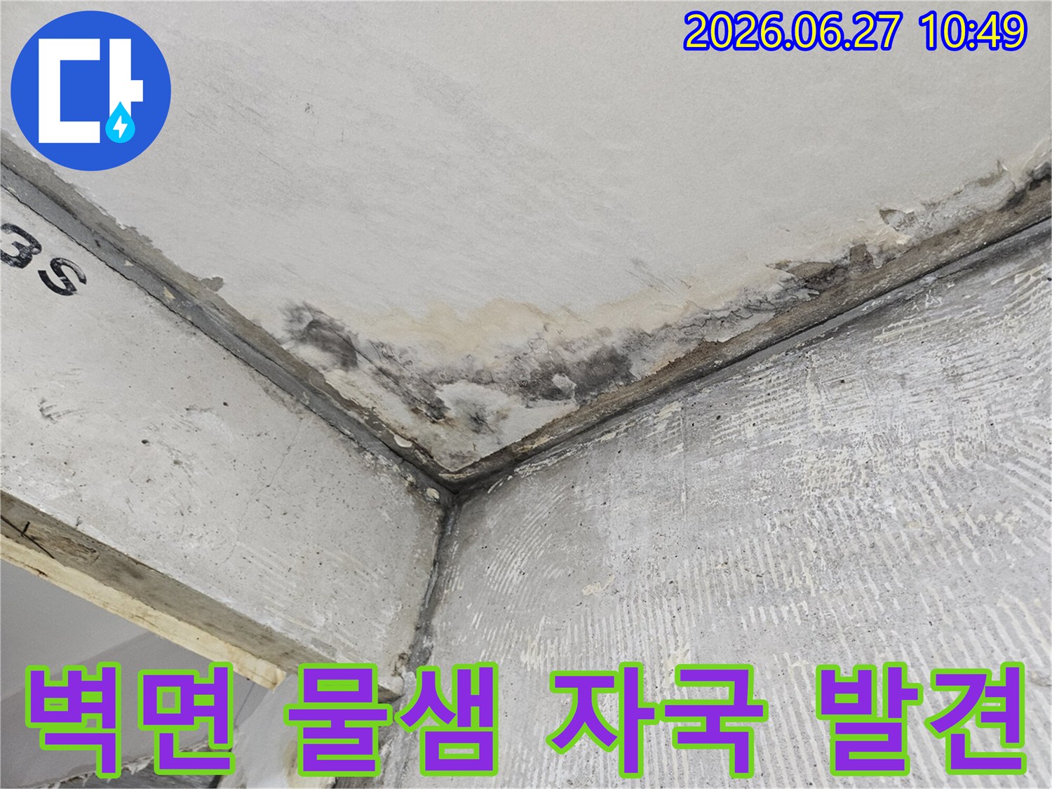 콘크리트 벽면과 천장 모서리에-오래된 듯한 물샘 자국과-습기로 인한 변색이 선명하게 나타나 있습니다