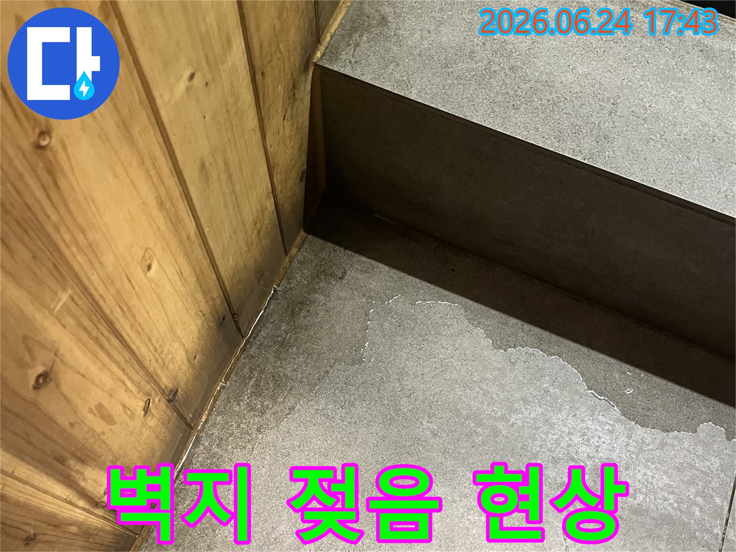 젖은-벽면과-나무-바닥의-경계에서-발견된-습기-현장으로-벽지-손상-우려