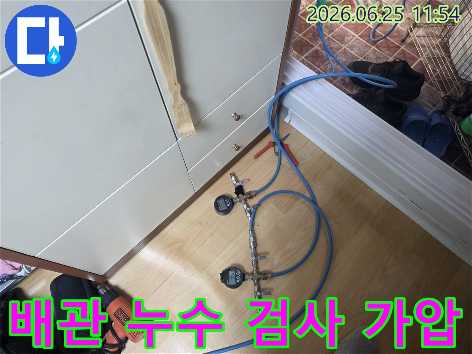 누수 엔지니어가 배관의 압력을 정밀하게 측정하고 누수 여부를 판단하기 위해 디지털 게이지가 장착된 가압 테스트 장비를 사용하고 있습니다