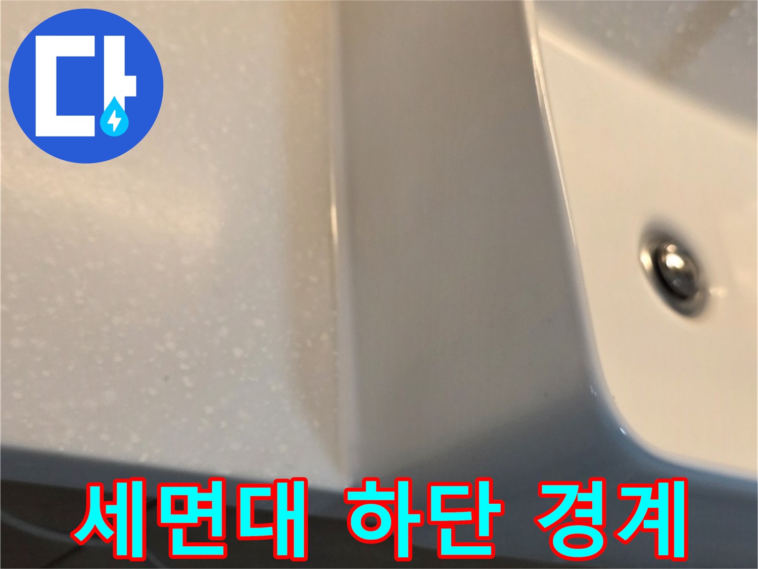 세면대 아래쪽 벽면 타일과 도기의 접합 부위 근접 촬영