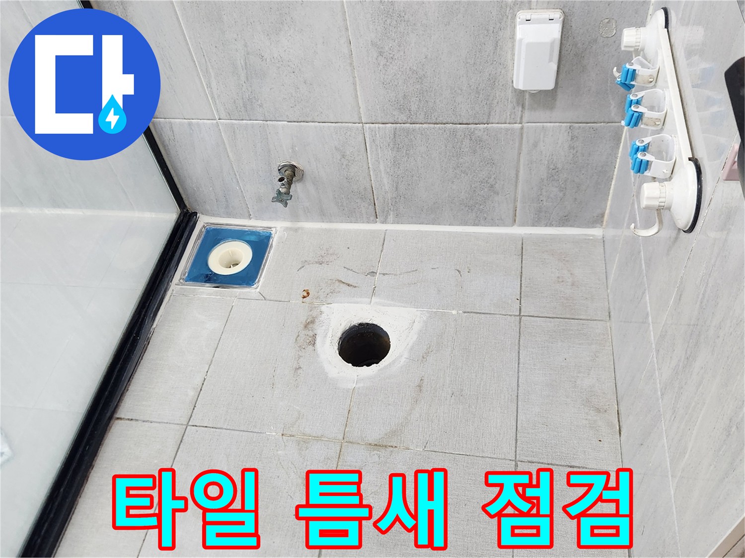 화장실 타일과 배수구 유가가 만나는 지점의 상태 사진입니다.