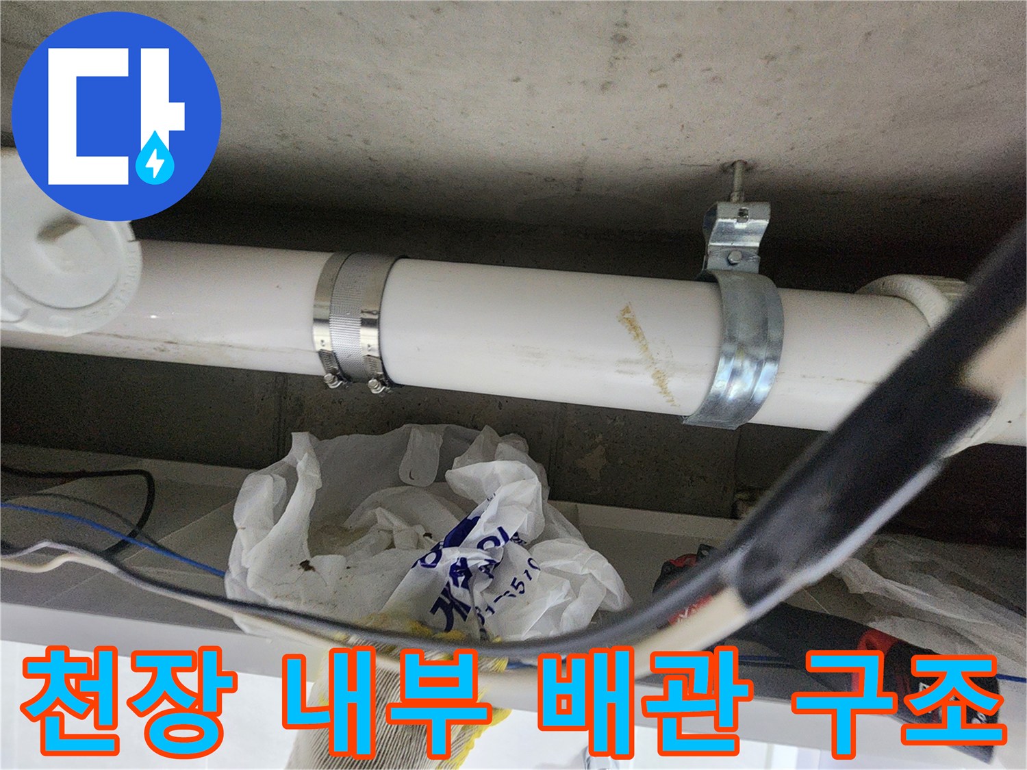 천장에 매립된 흰색 배관과 금속 고정 클램프