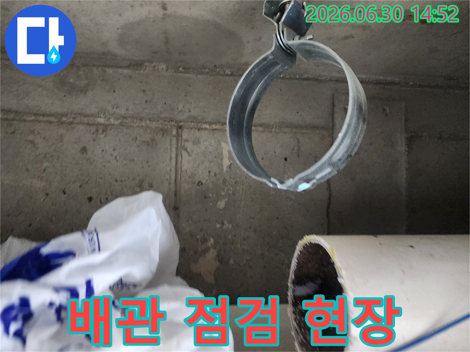콘크리트 천장에 고정된-배관과 그 주변의-누수 흔적을 보여주는-현장 점검 사진
