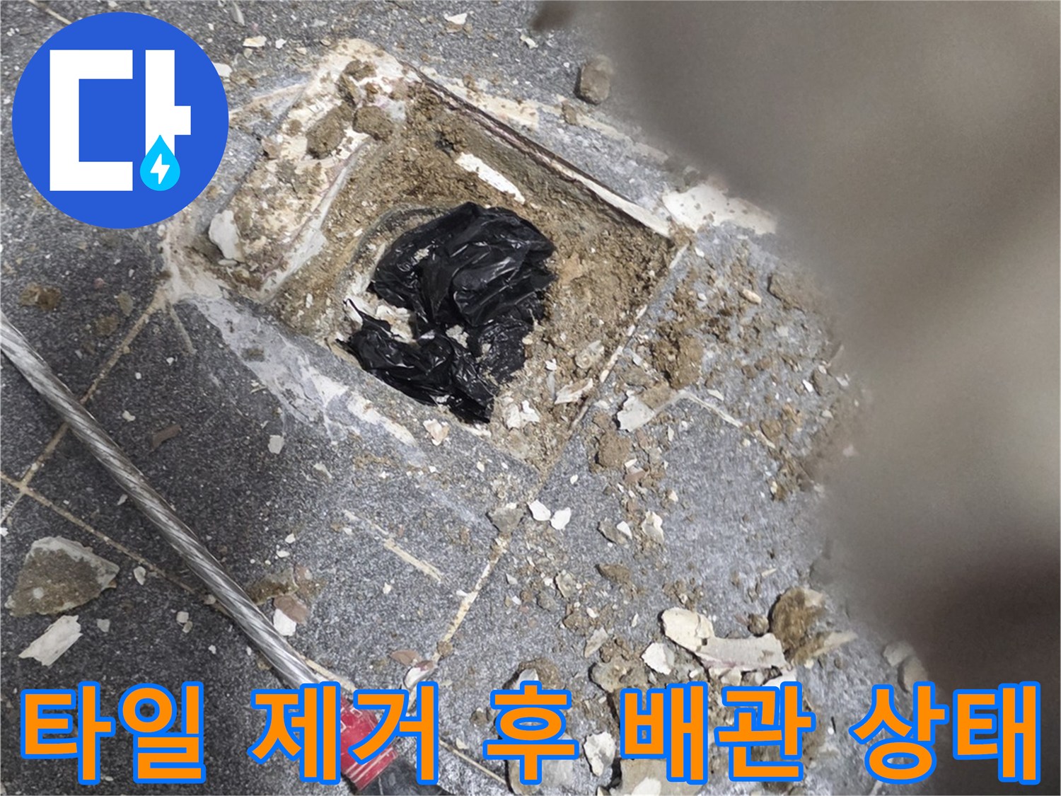 타일을 일부 제거하여 노출된 배수구 내부의 오염된 모습입니다.